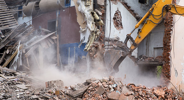 excavator demolishing residential structure