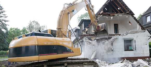 excavator tearing down house
