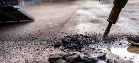 jackhammer breaking up concrete driveway