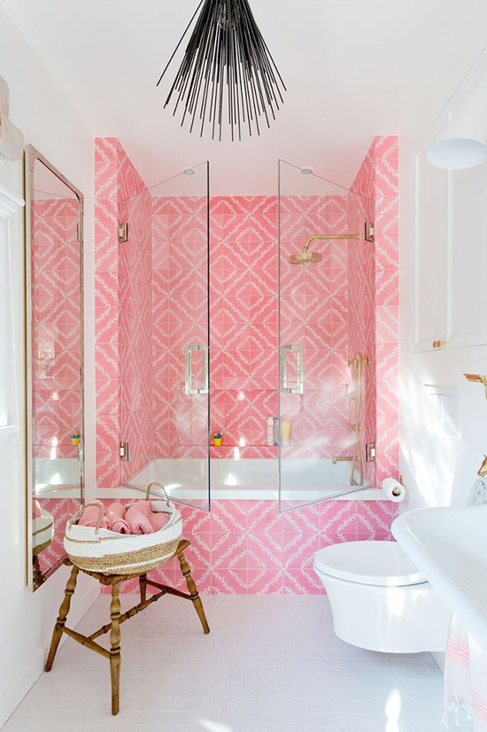 unique and bold black hanging light fixture in modern bathroom with pink tile