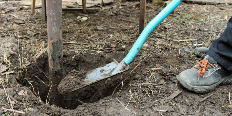 digging up wooden fence post