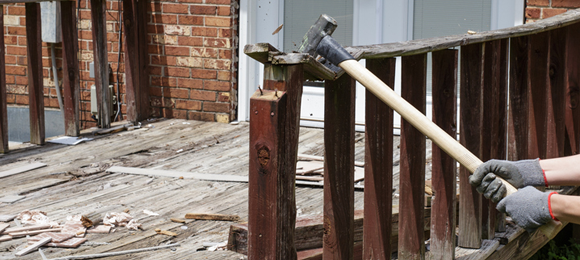 swinging sledgehammer at wood deck railing