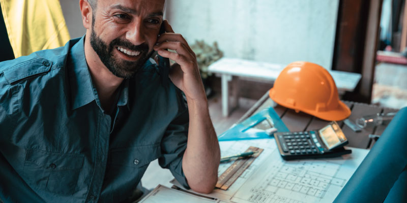 contractor at desk on phone