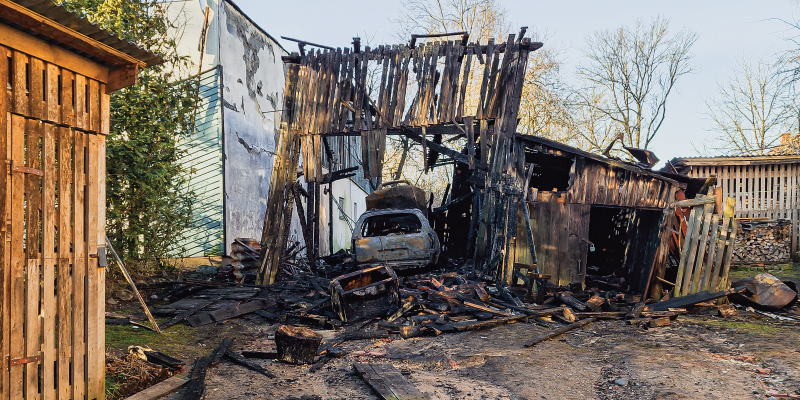 fire damaged barn with car parked inside