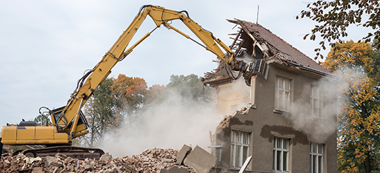 excavator demolishing 2 story house