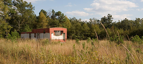 old mobile home sitting in empty field